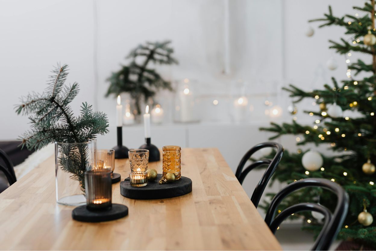 Gaumīgi izrotāts mājoklis Ziemassvētkiem ar eglīti, svecēm un galda dekorācijām